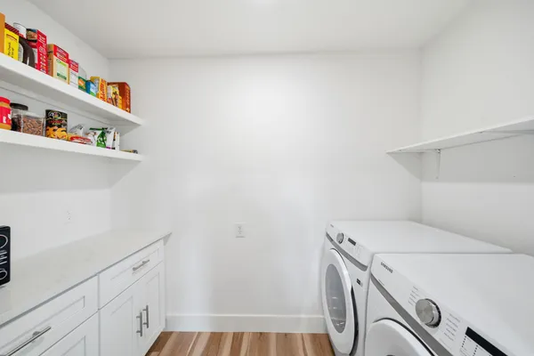 a kitchen with a sink a refrigerator and white cabinets