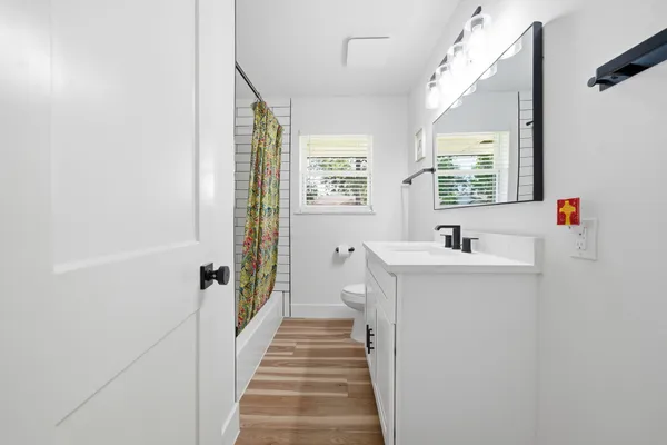 a bathroom with a sink a toilet and a large mirror