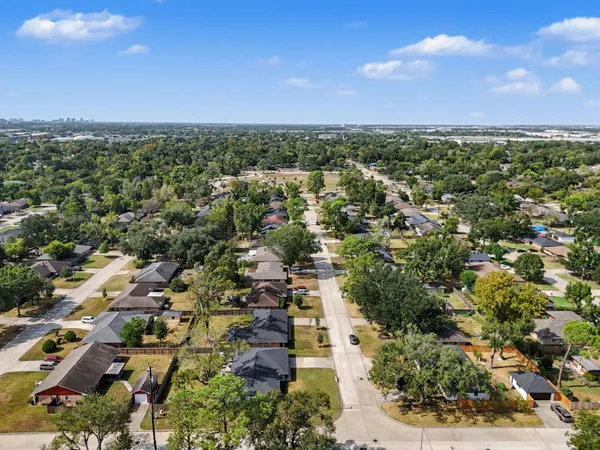 an aerial view of residential houses with outdoor space and trees