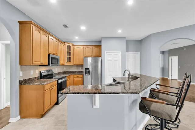 a kitchen with stainless steel appliances granite countertop a sink stove and refrigerator
