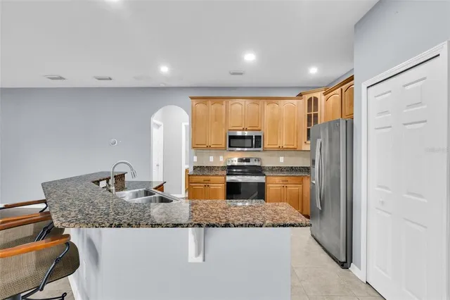 a kitchen with stainless steel appliances granite countertop a refrigerator a stove top oven a sink and dishwasher