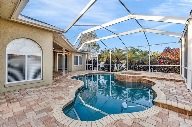 a view of a swimming pool with a chair and tables in the patio
