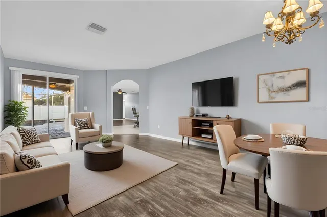 a living room with furniture a lamp and a wooden floor