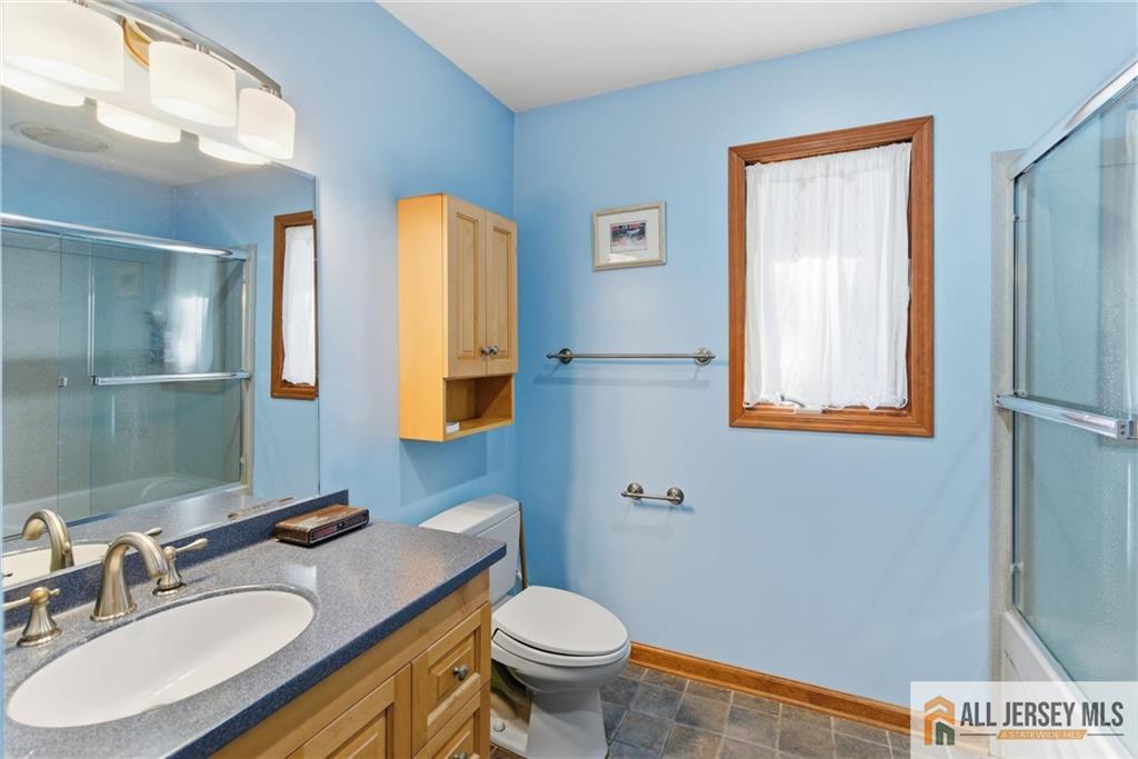 286 William Street Piscataway, NJ 08854 - Photo 16 of 23 a bathroom with a granite countertop toilet sink and mirror