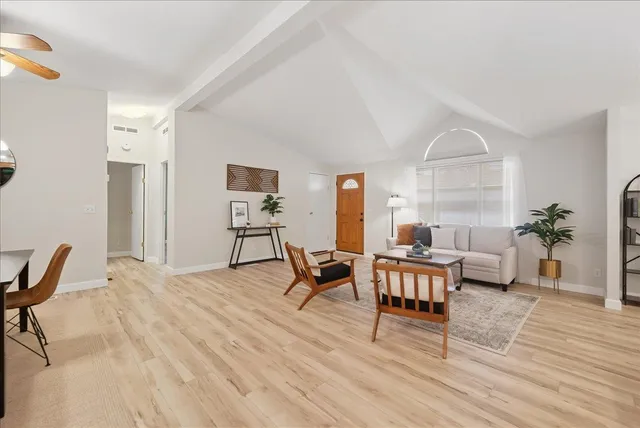a living room with furniture and a wooden floor
