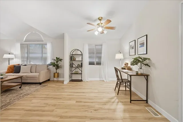 a living room with furniture kitchen view and a large window