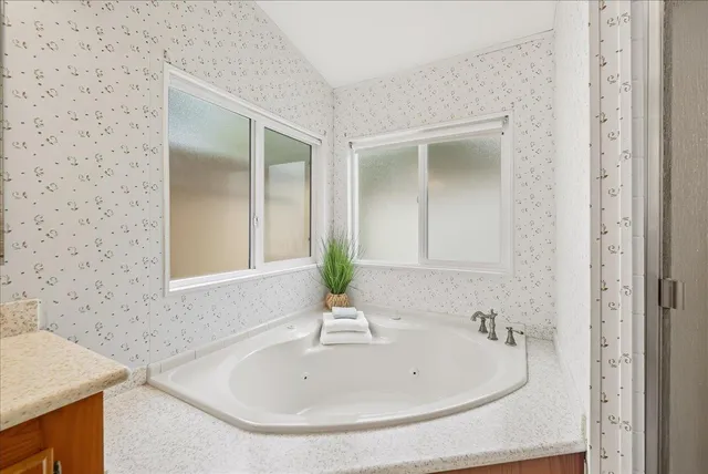 a spacious bathroom with a bathtub sink and mirror