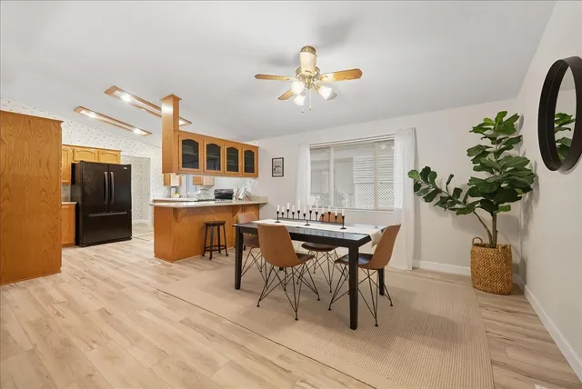 a dining room filled a chandelier and kitchen view