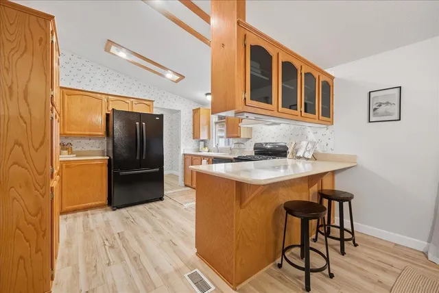 a kitchen with stainless steel appliances granite countertop a refrigerator a sink and a stove