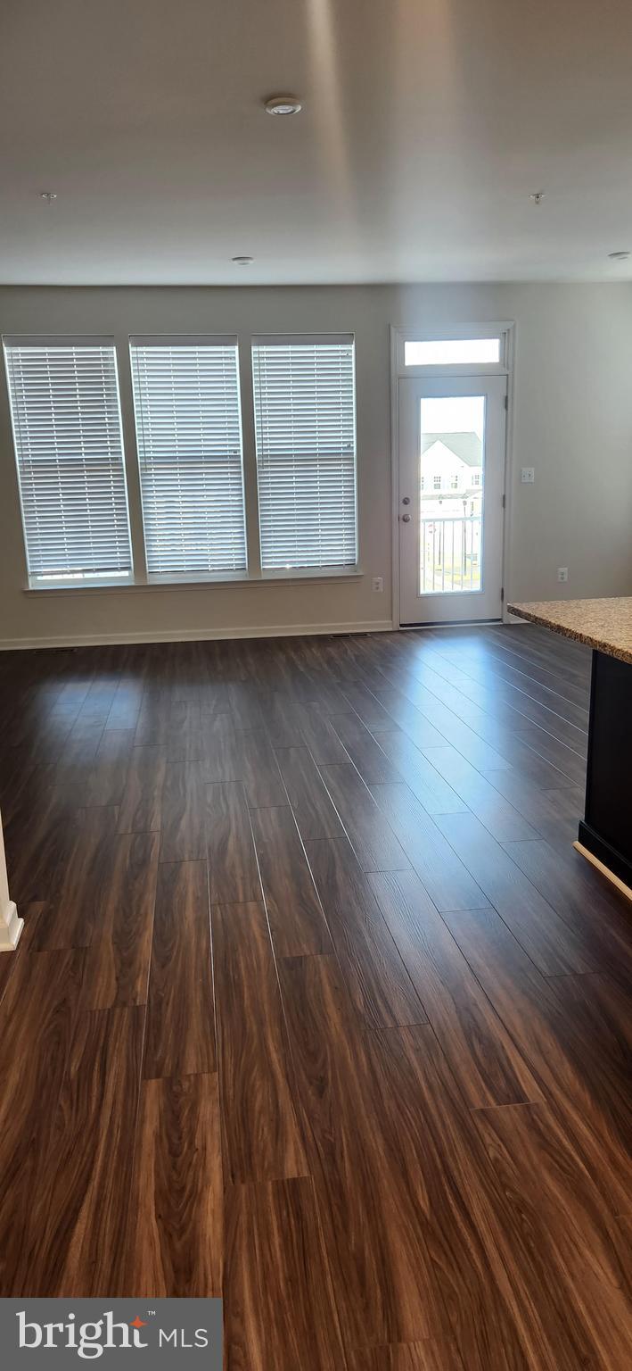 225 Aspen Road, Unit 103 Stafford, VA 22554 - Photo 4 of 8 wooden floor in an empty room with a window