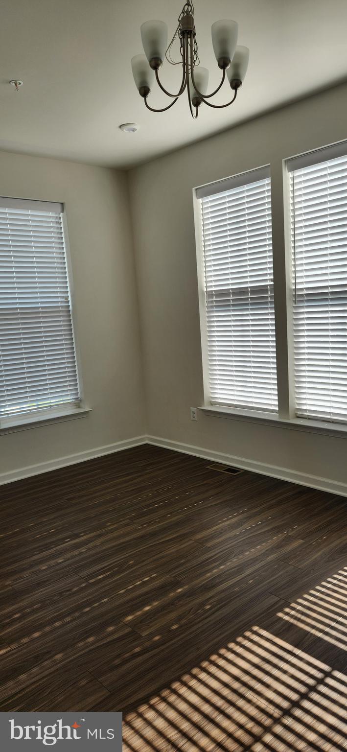 225 Aspen Road, Unit 103 Stafford, VA 22554 - Photo 5 of 8 an empty room with wooden floor and windows