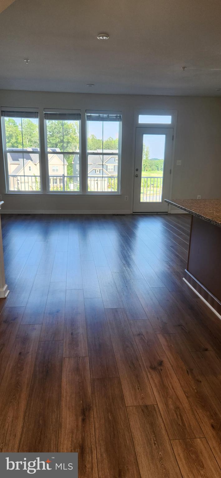 225 Aspen Road, Unit 103 Stafford, VA 22554 - Photo 6 of 8 an empty room with wooden floor and windows
