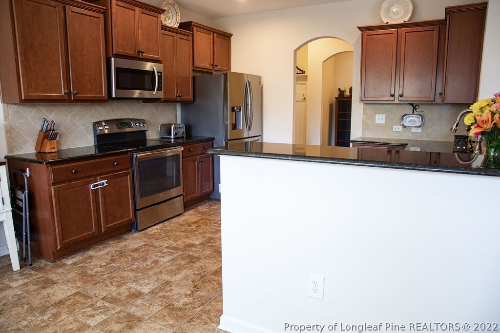 115 Stonehurst Drive Spring Lake, NC 28390 - Photo 16 of 50 a kitchen with stainless steel appliances granite countertop a stove a sink and a refrigerator