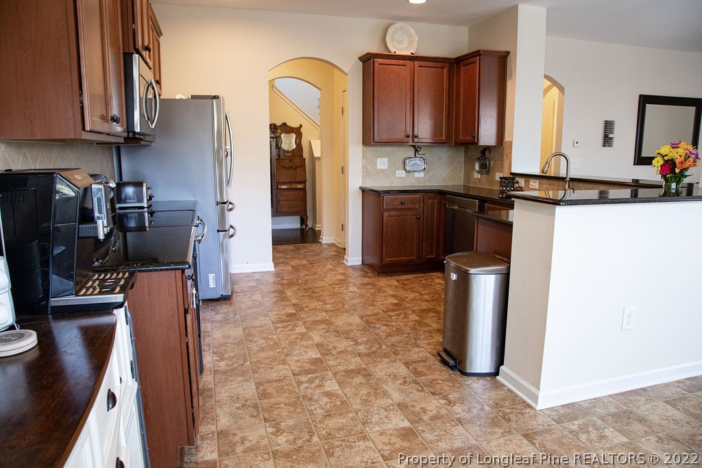 115 Stonehurst Drive Spring Lake, NC 28390 - Photo 17 of 50 a kitchen with stainless steel appliances a refrigerator sink and cabinets
