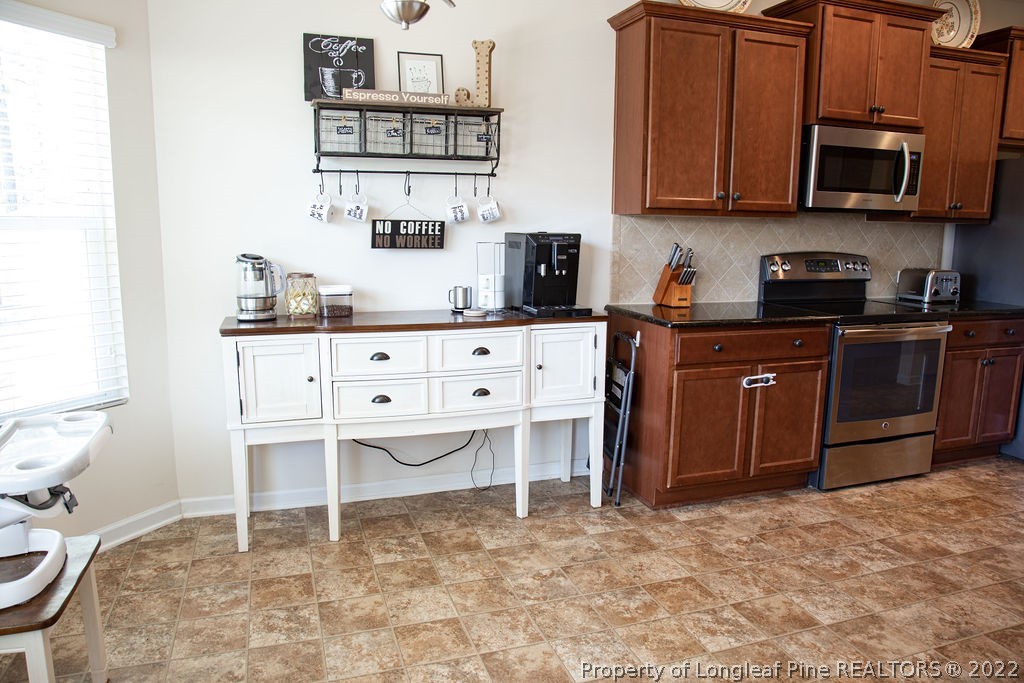 115 Stonehurst Drive Spring Lake, NC 28390 - Photo 18 of 50 a kitchen with stainless steel appliances granite countertop a stove a sink and a microwave