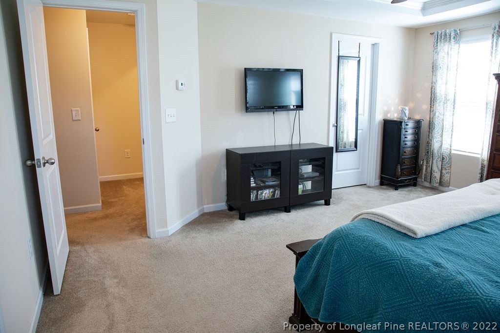 115 Stonehurst Drive Spring Lake, NC 28390 - Photo 36 of 50 a bedroom with a bed and a flat tv screen on wall