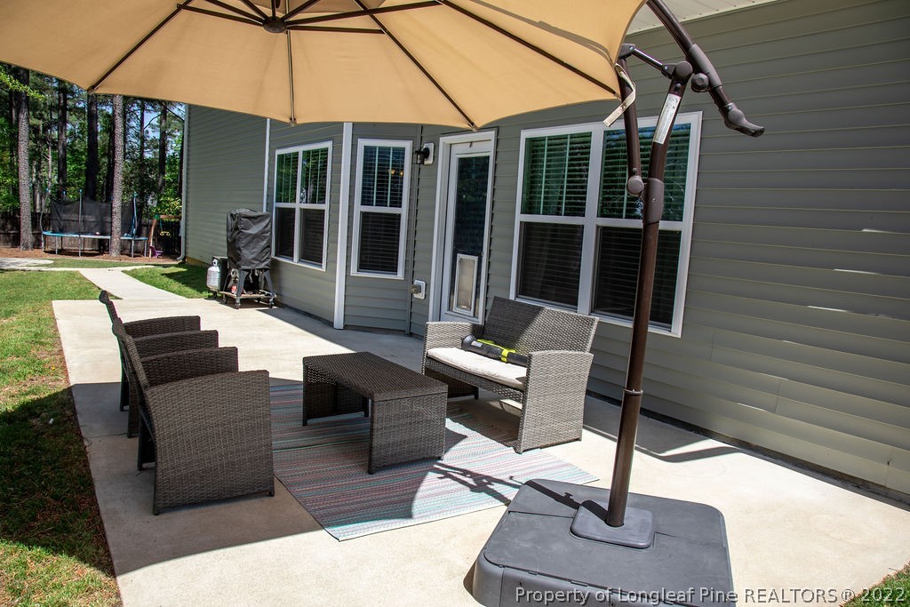 115 Stonehurst Drive Spring Lake, NC 28390 - Photo 47 of 50 a view of a patio with couches table chairs and a fire pit