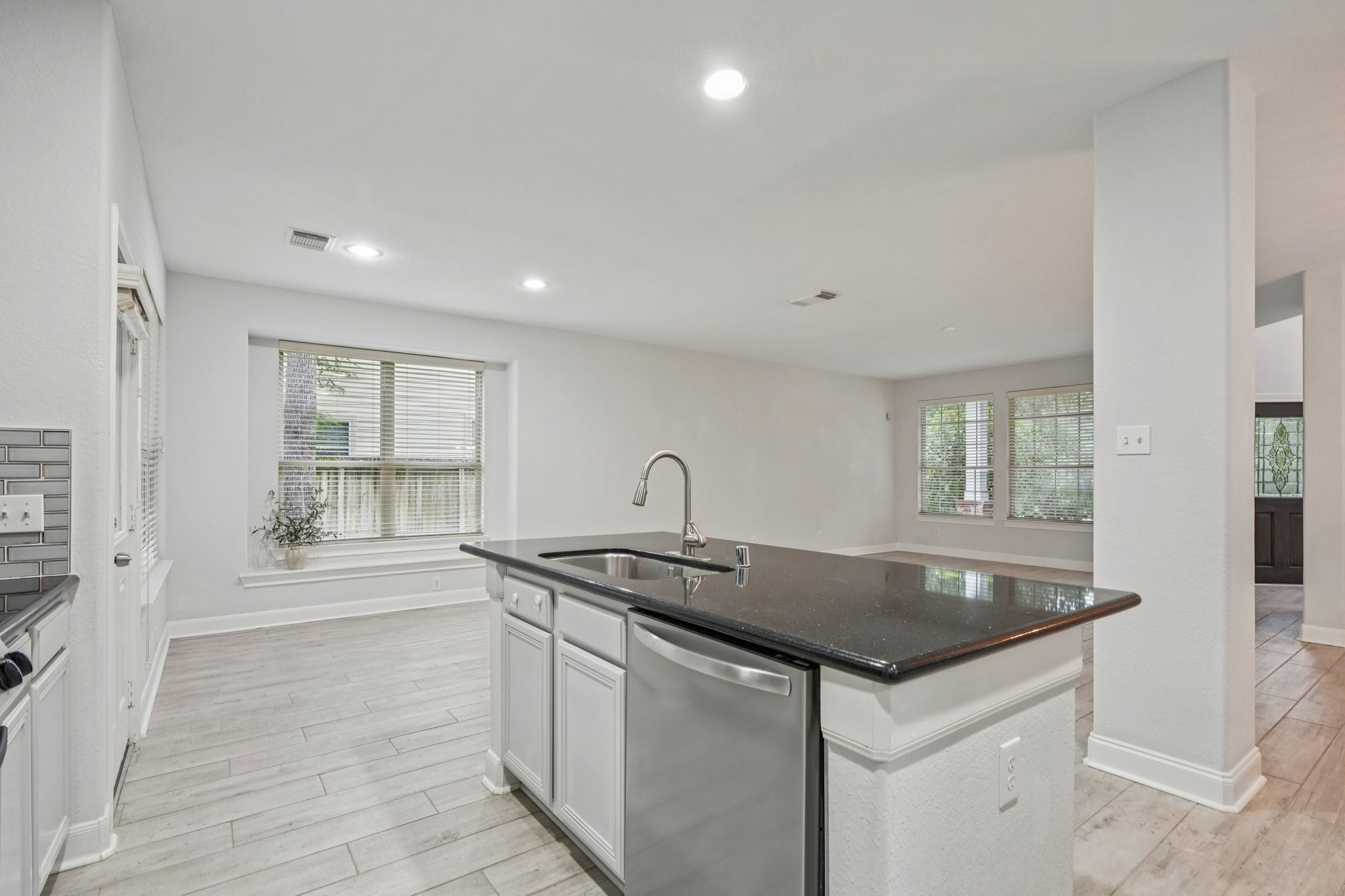 90 Panterra Way Spring, TX 77382 - Photo 13 of 43 a kitchen with granite countertop a sink and dishwasher with wooden floor
