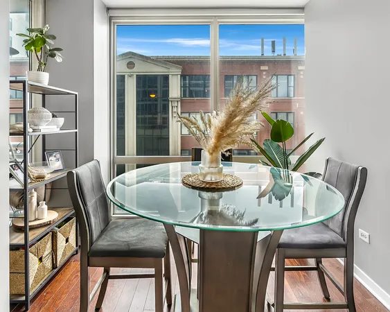 a view of a dining room with furniture a potted plant and wooden floor