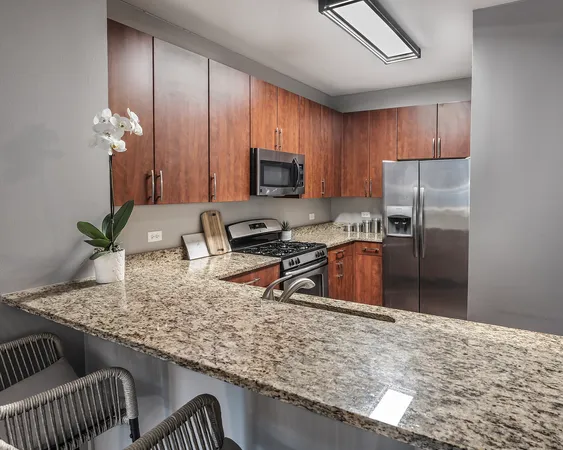 a kitchen with stainless steel appliances granite countertop a sink refrigerator and microwave