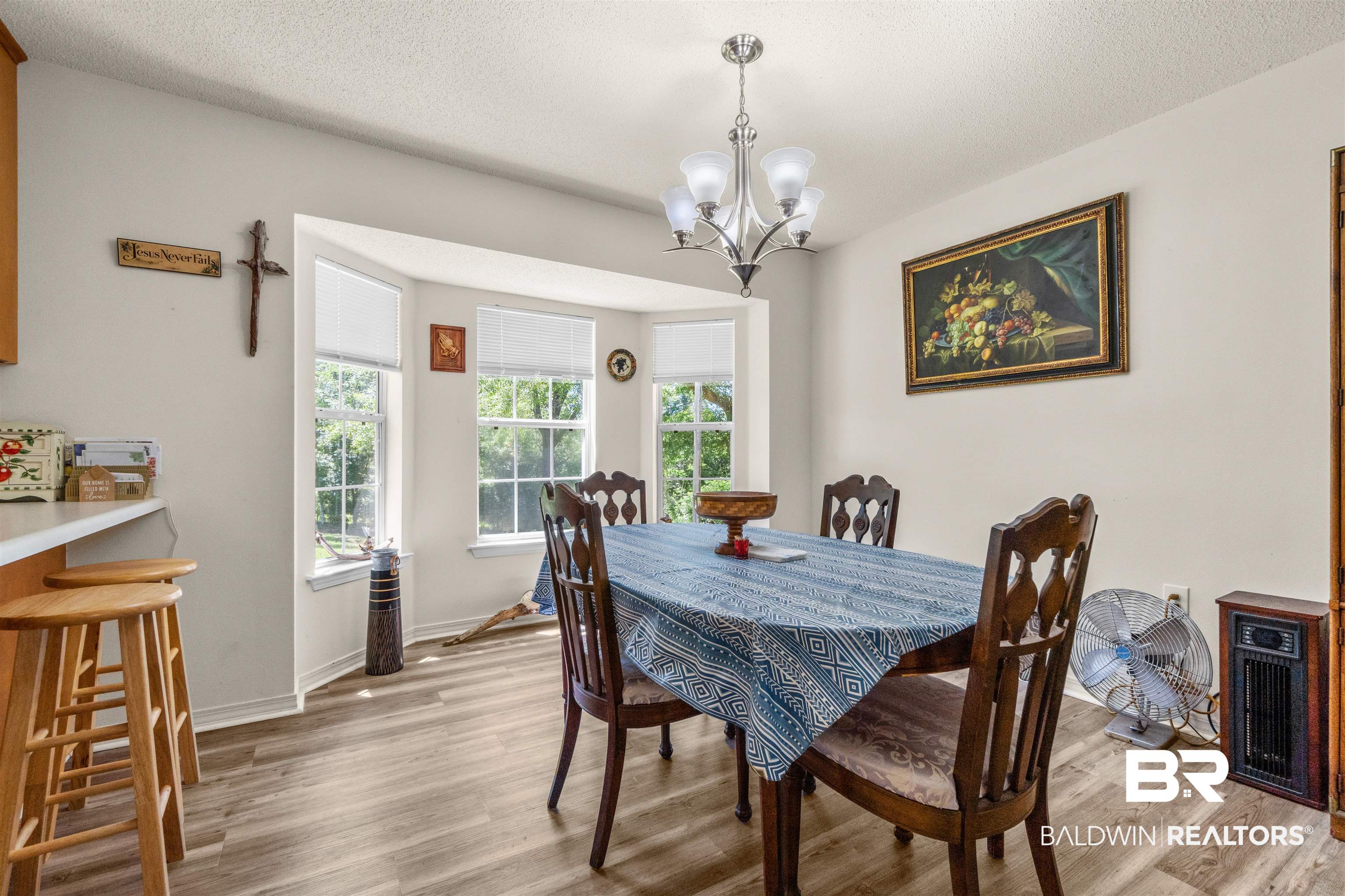35893 Pine Road South Stapleton, AL 36578 - Photo 12 of 31 Dining space featuring wood-finish flooring, a bay window with multiple panes, and a chandelier light fixture