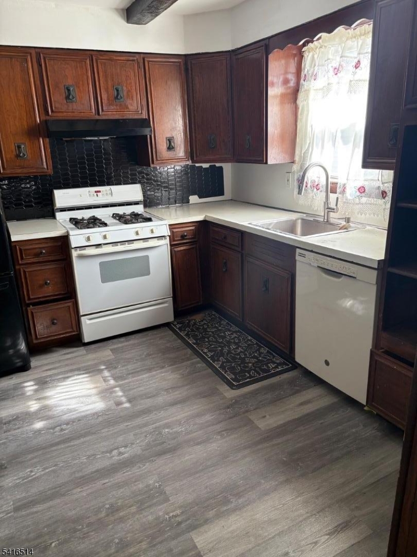 a kitchen with a sink cabinets appliances and a window