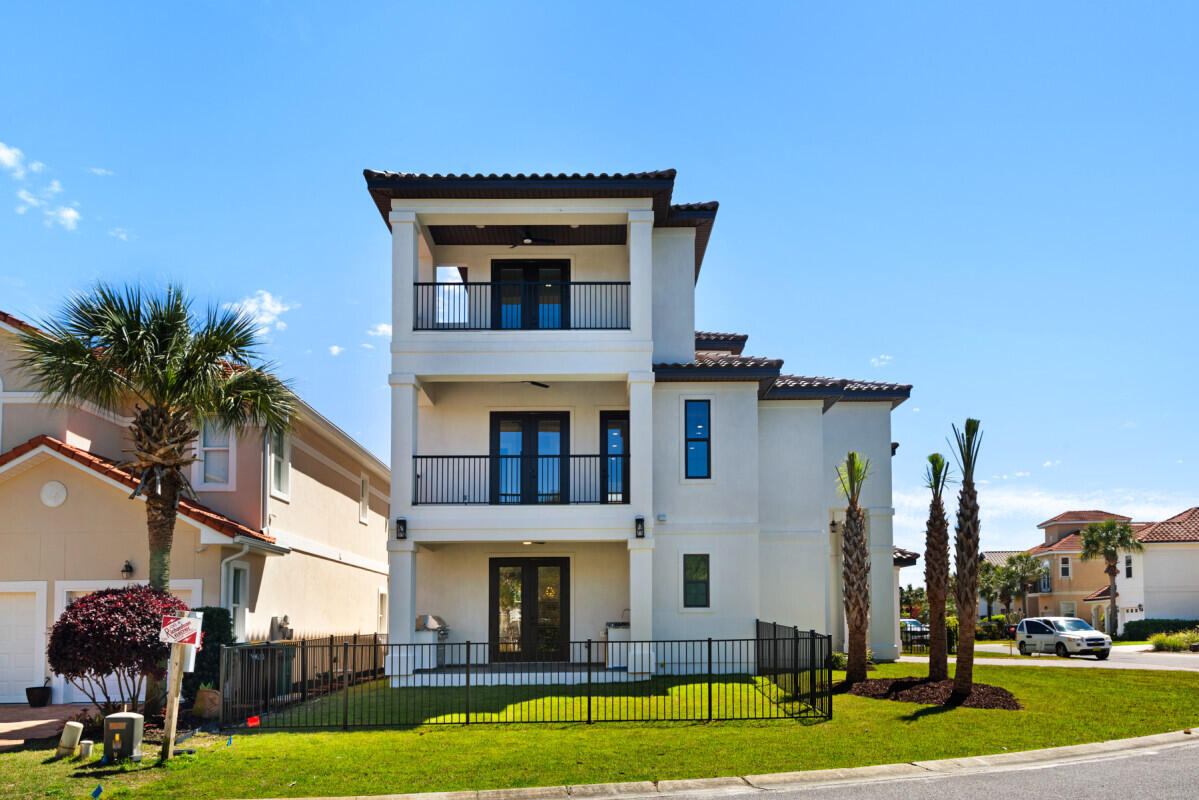 263 Calusa Boulevard Destin, FL 32541 - Photo 1 of 12 a front view of residential houses with yard and green space