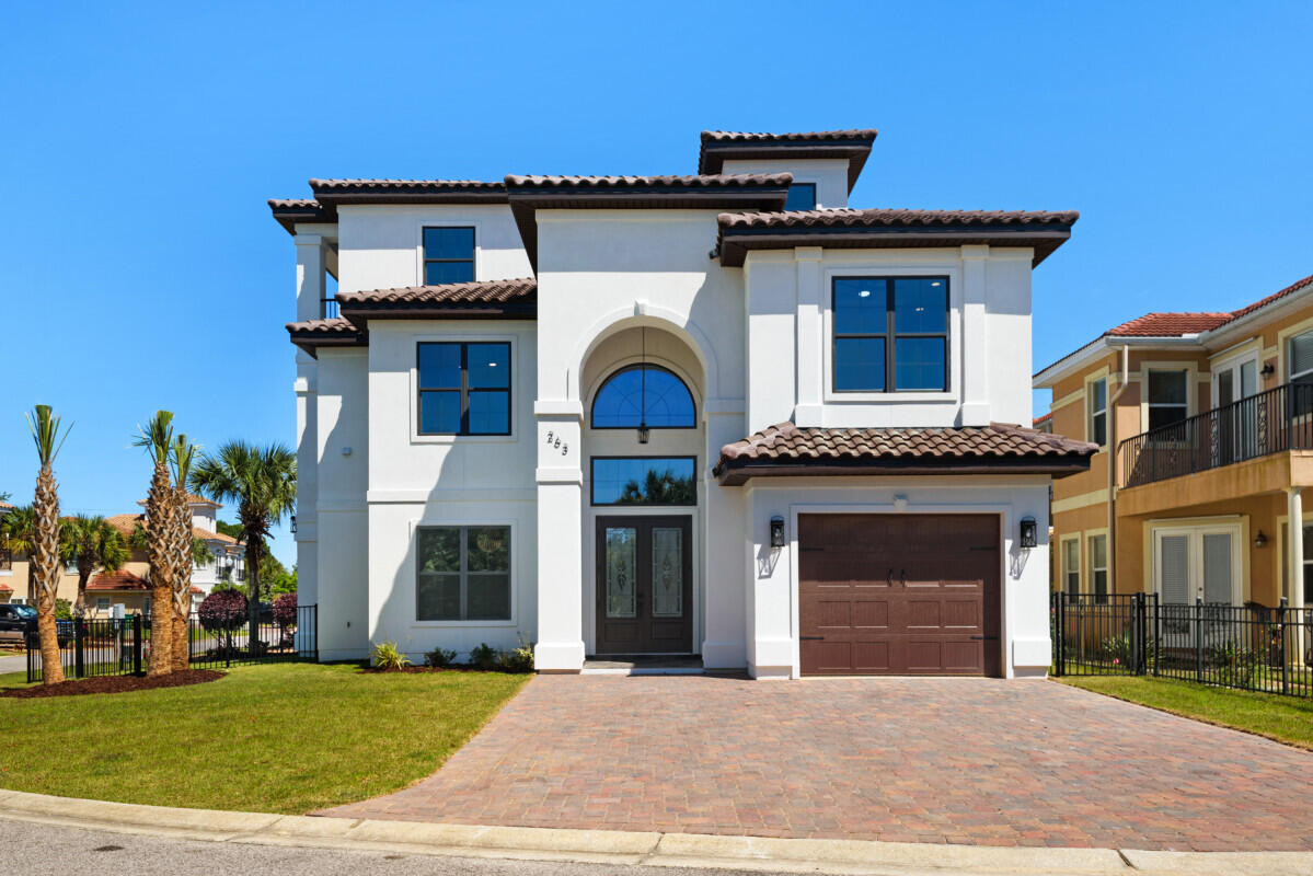 263 Calusa Boulevard Destin, FL 32541 - Photo 2 of 12 a front view of a house with a garden and plants