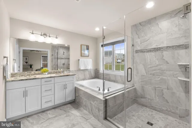a bathroom with a tub sink and mirror