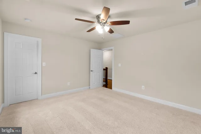 a view of an empty room with a ceiling fan