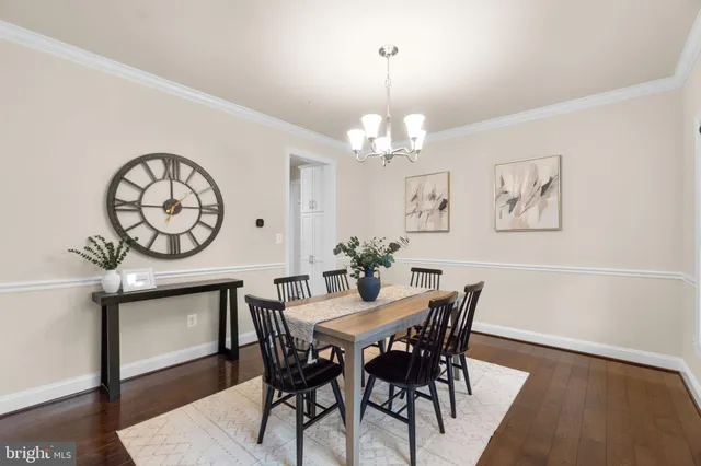 a view of a dining room with furniture a chandelier and wooden floor