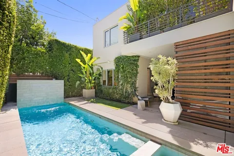 a view of a backyard with chair and potted plants