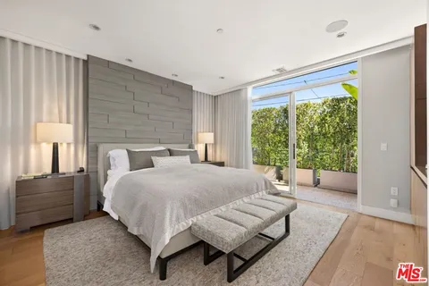 a bedroom with a bed and large window