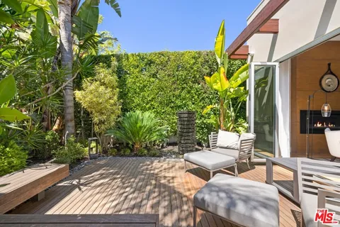 a view of a patio with table and chairs and potted plants