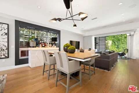 a dining room with furniture a chandelier and wooden floor