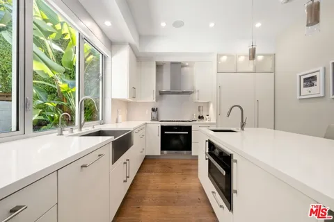 a large kitchen with stainless steel appliances granite countertop a white stove top oven sink and cabinets