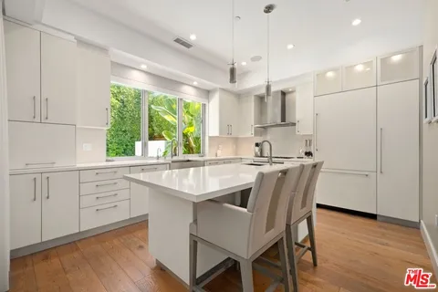 a kitchen with kitchen island granite countertop a sink a center island and cabinets
