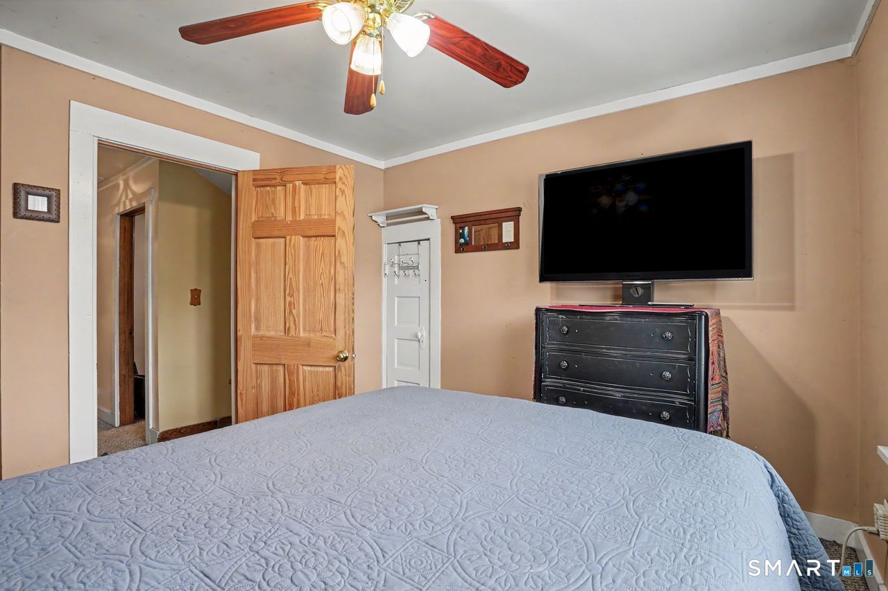 74 Maple Street Seymour, CT 06483 - Photo 23 of 40 a bedroom with a bed and a flat screen tv