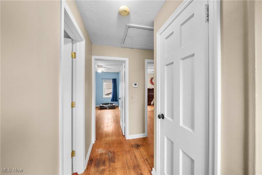 4819 Westbourne Road Cleveland, OH 44124 - Photo 31 of 39 Corridor featuring baseboards, wood finished floors, and a textured ceiling