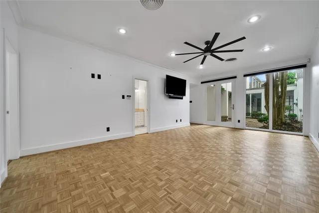 a view of an empty room with a window and a ceiling fan