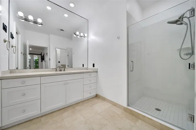 a spacious bathroom with a shower a sink and a mirror