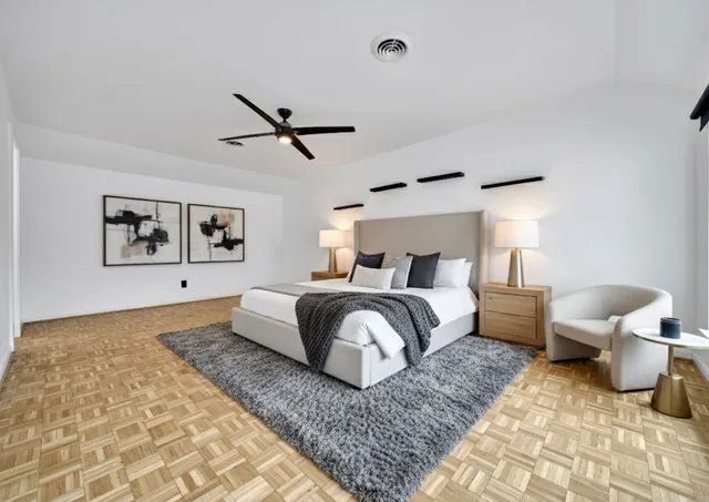 a bedroom with a large bed and a chandelier