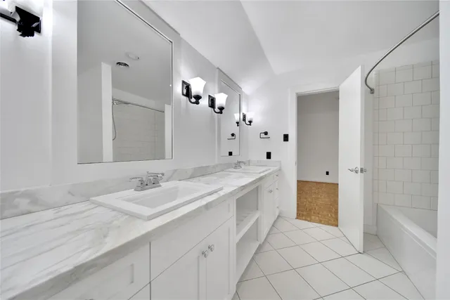 a spacious bathroom with a granite countertop sink a toilet a mirror and bathtub