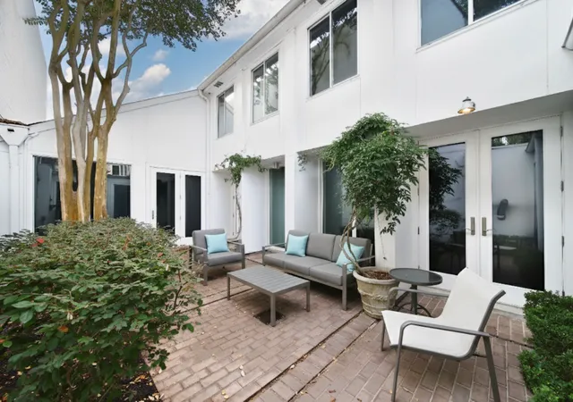 a view of a patio with couches table and chairs and potted plants