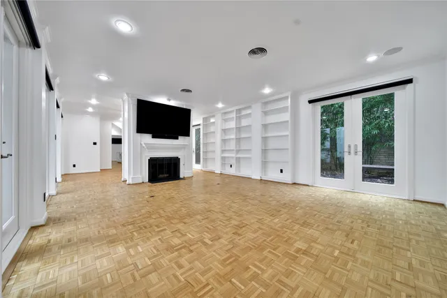 a view of a livingroom with a fireplace a kitchen and a window