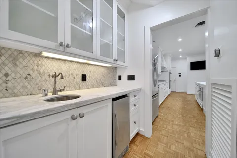 a kitchen with a sink and white cabinets