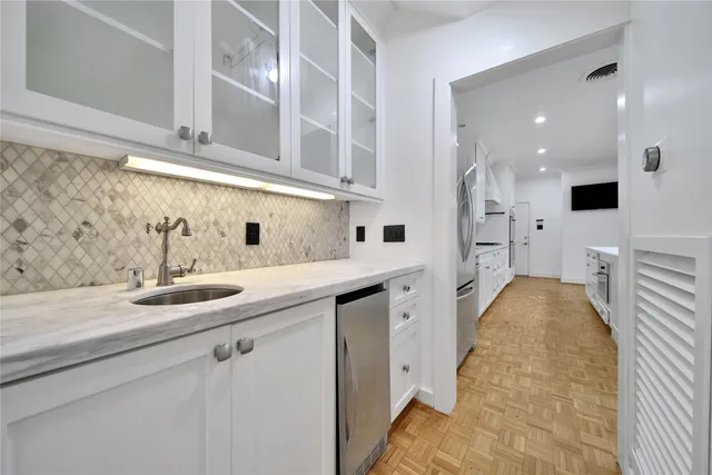 a kitchen with a sink and white cabinets