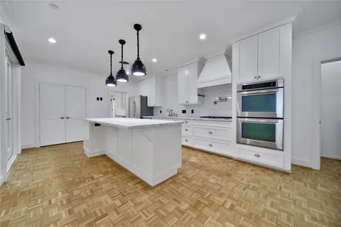 a large kitchen with kitchen island a sink stainless steel appliances and cabinets