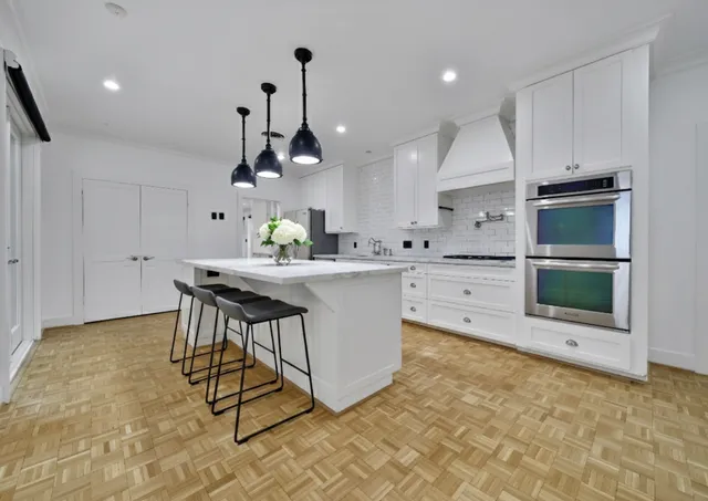 a kitchen with stainless steel appliances a sink a stove a microwave a center island and cabinets