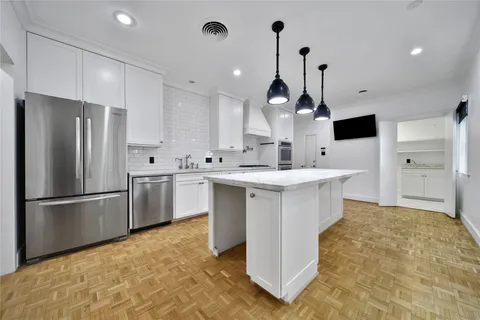 a kitchen with kitchen island a sink stainless steel appliances and cabinets